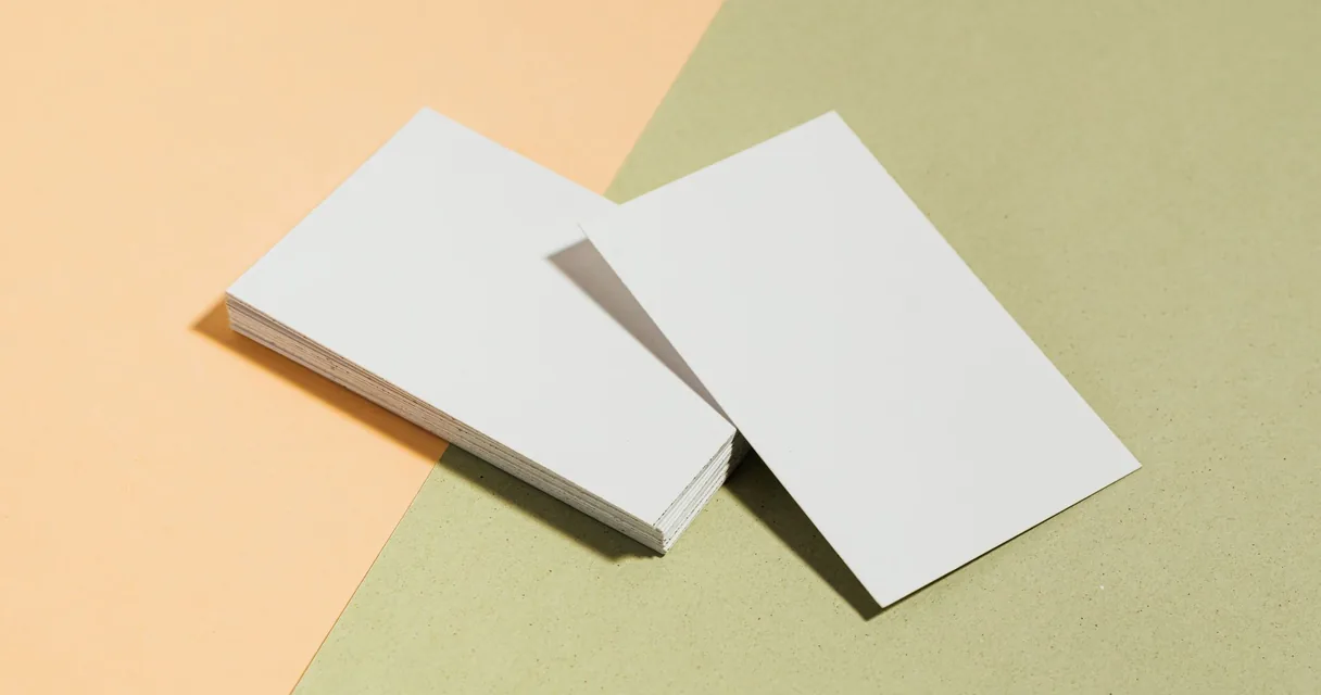Pilha de cartões de visita em branco sobre uma superfície em tons pastel